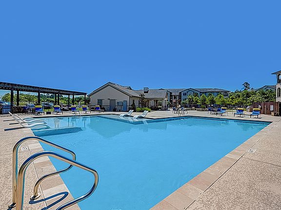Pool with lounging chairs in water and lounge chairs with pillows