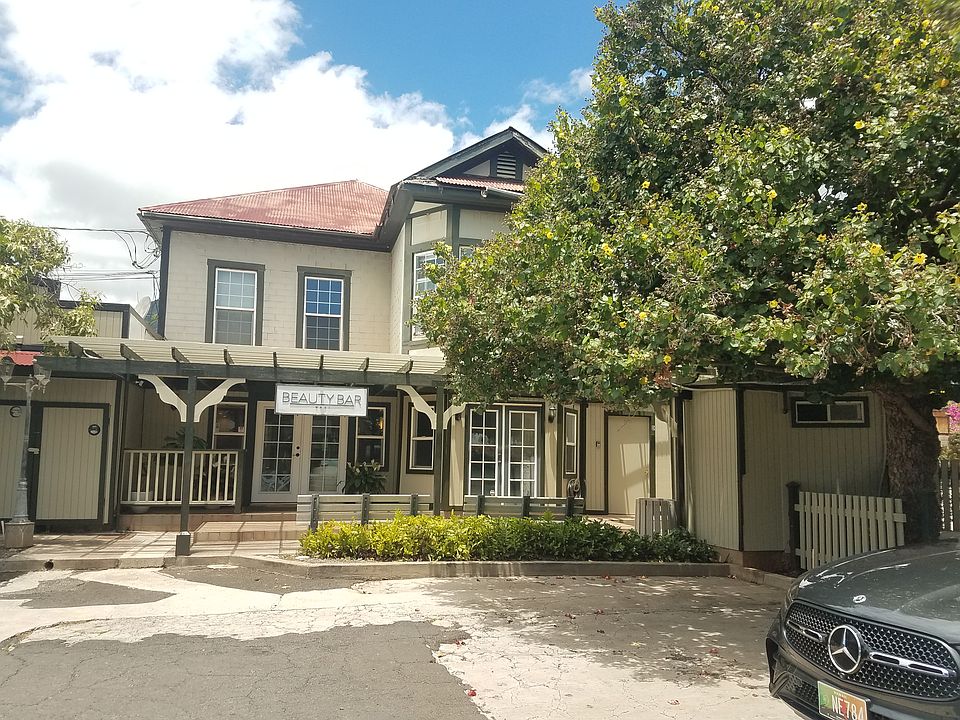 Exterior looking mauka. Residential apartment is the full 2nd floor, accessed via hall on the right side of this photo. A few parking lot shade trees.