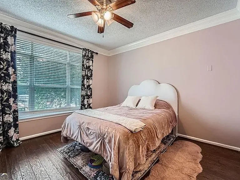Broad picture window provides natural light. Trees and venetian blinds offer privacy.