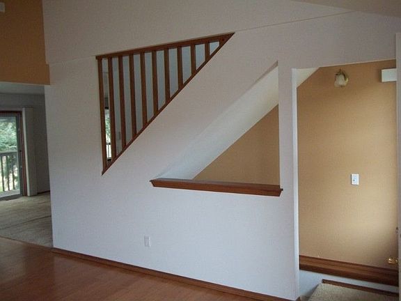 As seen in living room, stairs on right to lower level, stairs above to master suite
