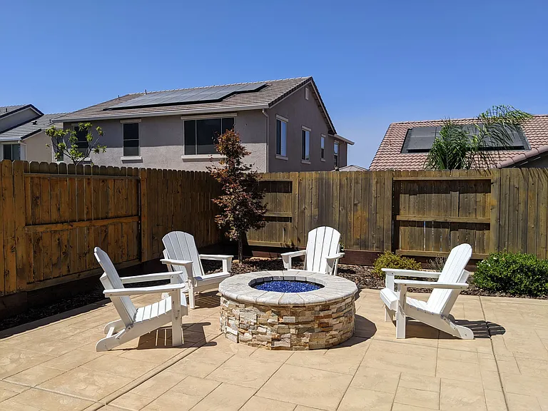 Entertain in style with your private backyard retreat, featuring a custom fire pit and ample seating area. This serene outdoor space is designed for cozy evenings under the stars and relaxing weekends in your own personal oasis.