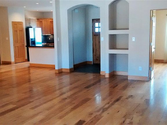 Main living area looking into kitchen, main entry, front office or 4th bedroom.