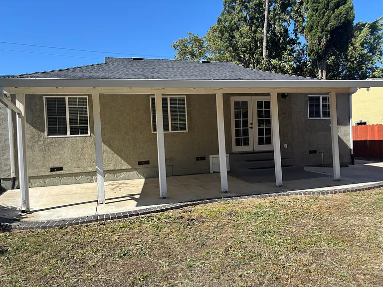 View of large backyard with spacious covered patio, excellent for comfortable outdoor entertaining.