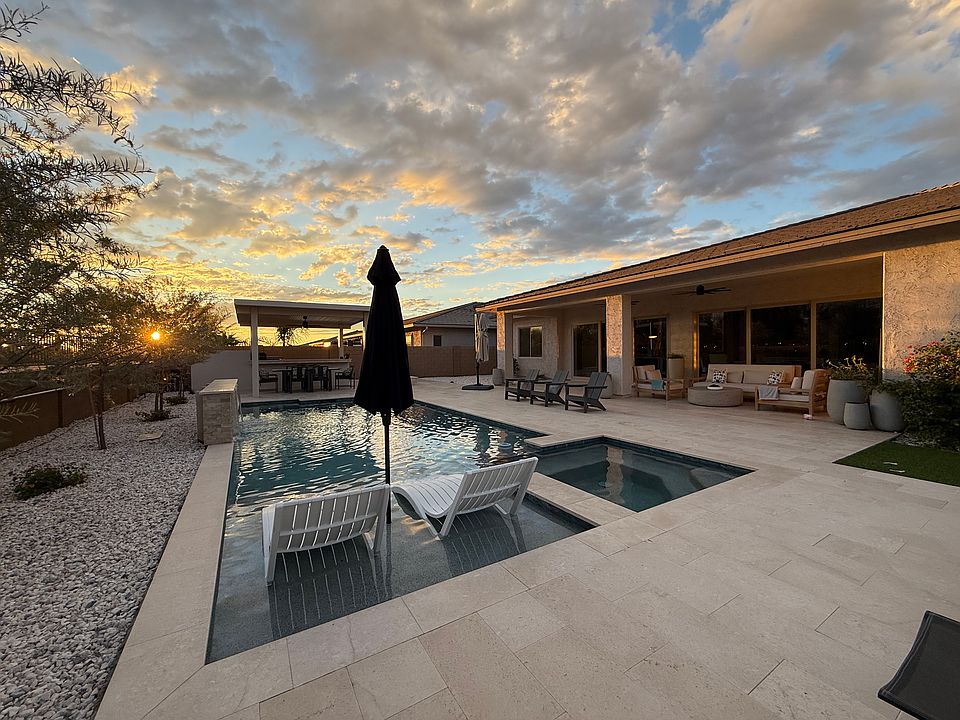 Backyard with heated pool, jacuzzi, fire pit and outdoor kitchen.