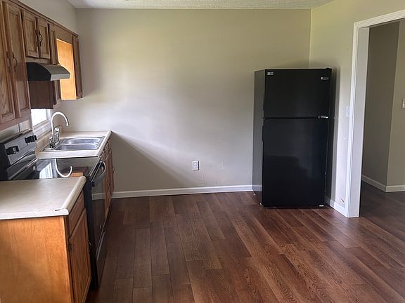 Kitchen/dining area with included range, range hood, and refrigerator