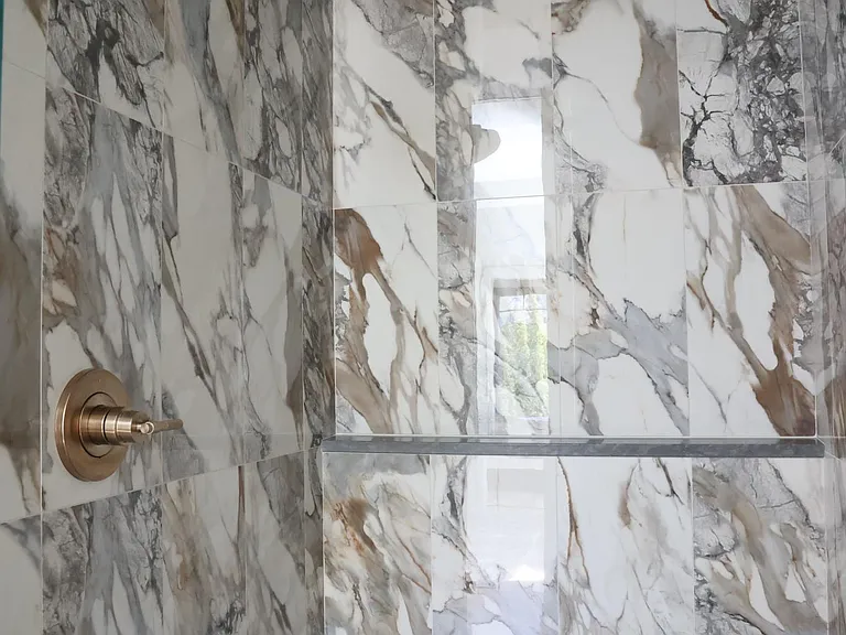 Large, walk in shower with bench in primary bathroom.