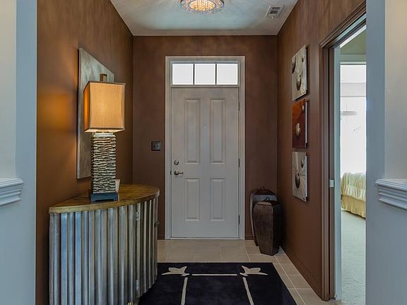 Come on in!  This roomy foyer has beautiful 12" tiled flooring and custom painting.  Note the art niche on the far right and left  that is lit for your special displays.  In addition, the foyer is separated from the guest bath and guest bedroom by a pocke