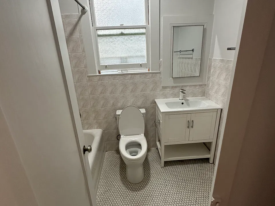 Bathroom , toilet, sink and small cubby behind mirror