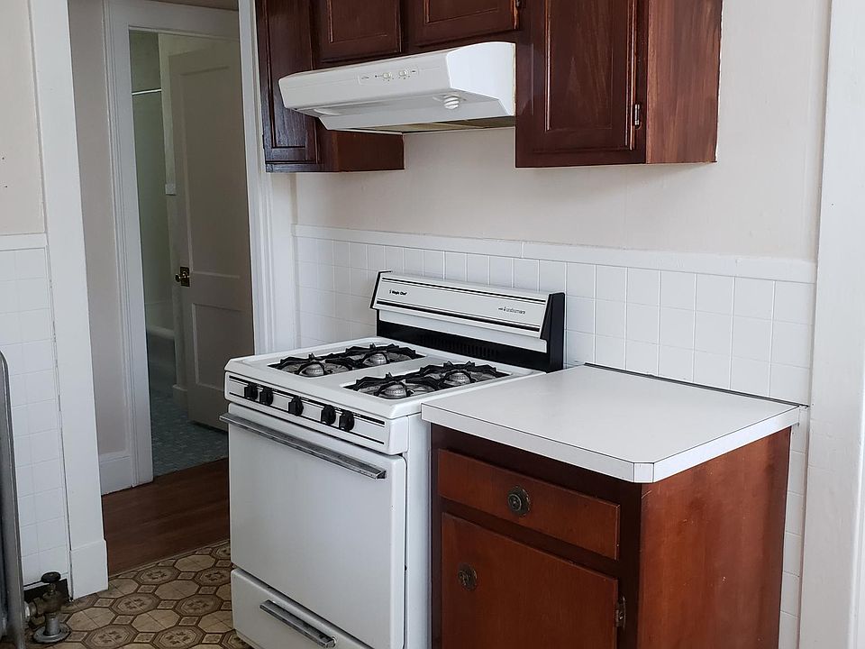 picture of kitchen with stove with over head cabinets and counter on the side for additional storage.