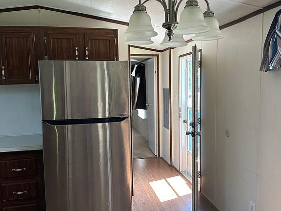 View from Kitchen showing back door to uncovered deck. Past this is the washer/dryer & Master Bedroom