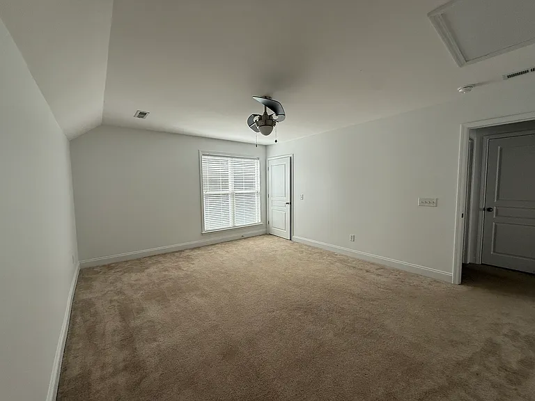 Generously sized upper-level bedroom offering a clean layout with crisp white trim, excellent wall space for furniture setups, and its own private closet."