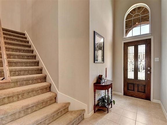 Light and bright foyer with beautiful leaded glass door and arched window