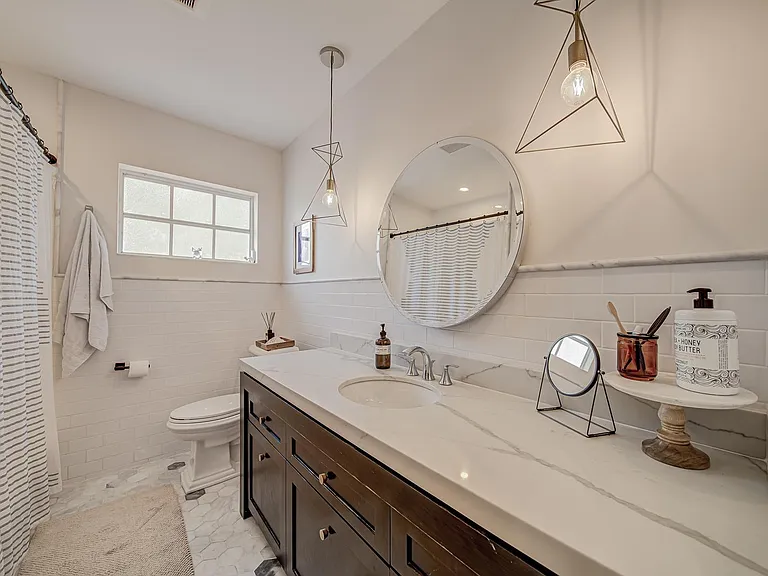 Main bathroom has quartz countertops and marble hexagon tile.