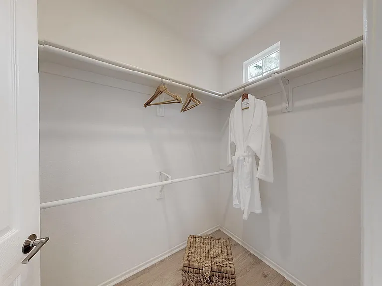 Walk-in closet with shelving, rods, and window.