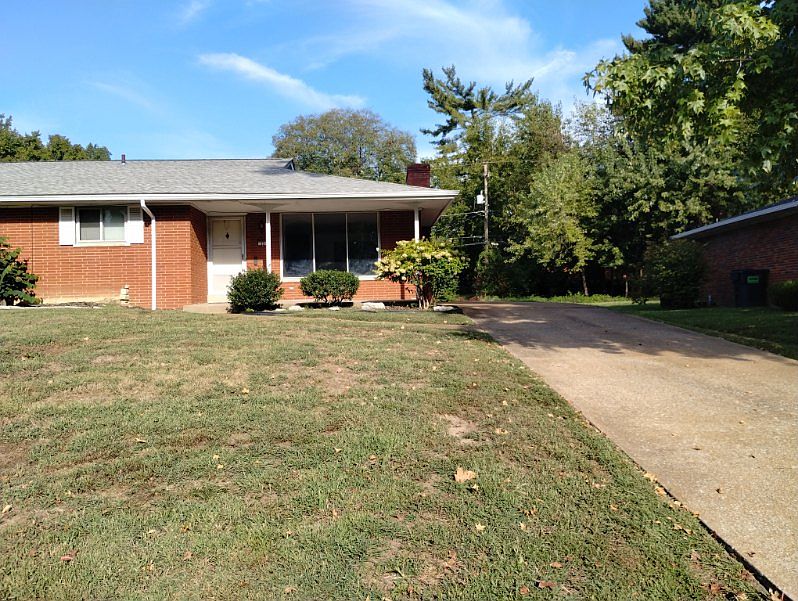 Front of duplex has a long driveway.