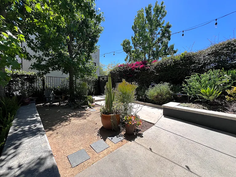 Beautifully landscaped communal courtyard featuring secure entry, comfortable garden seating, and a peaceful open-air design.