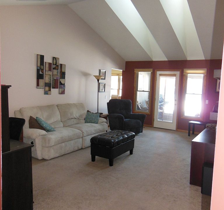 Large open living room with vaulted ceilings and skylights.