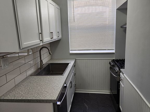 One side of the kitchen with brand new floors, counter tops, stainless steel appliances including Stove, Fridge, Dishwasher