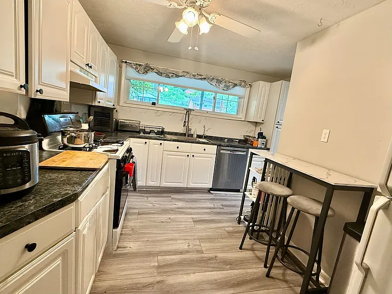 Fully stocked kitchen with gas stove, dishwasher, and every tool included _ Instant Pot, air fryer, food processor, pots and pans, cutting boards. Big sink with disposal, generous counter space, and a neighborhood view from the window