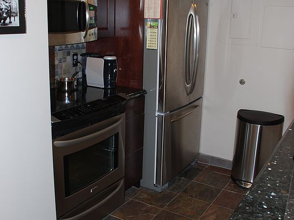Updated kitchen - stainless steel and cherry cabinets with slate floors.
