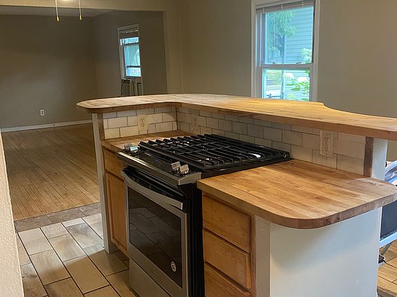 Kitchen has butcher block counters, open to the living room.