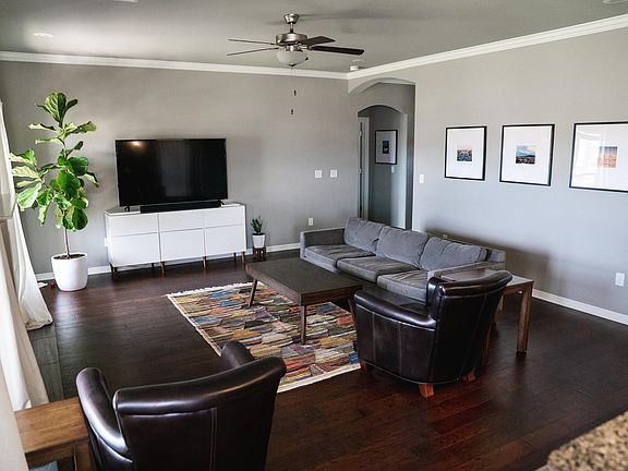 Open living area with south-facing windows, high ceilings, gas fireplace, and laminate floors.