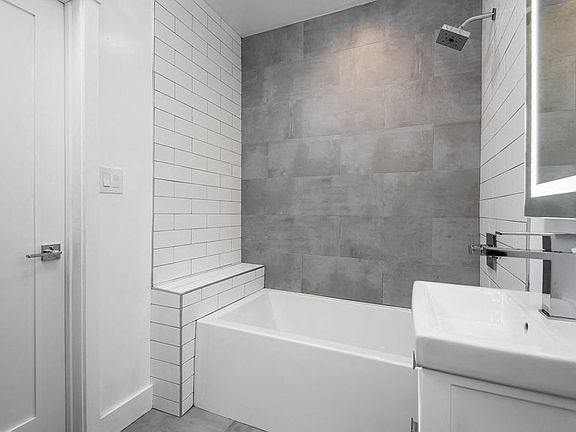 Modern bathroom with off-set tiling and custom fixtures at 4141 Normal Avenue apartment homes in Los Angeles, California.