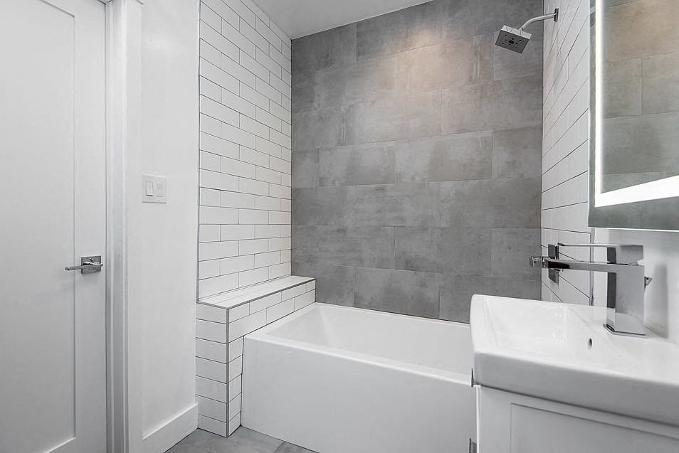 Modern bathroom with off-set tiling and custom fixtures at 4141 Normal Avenue apartment homes in Los Angeles, California.