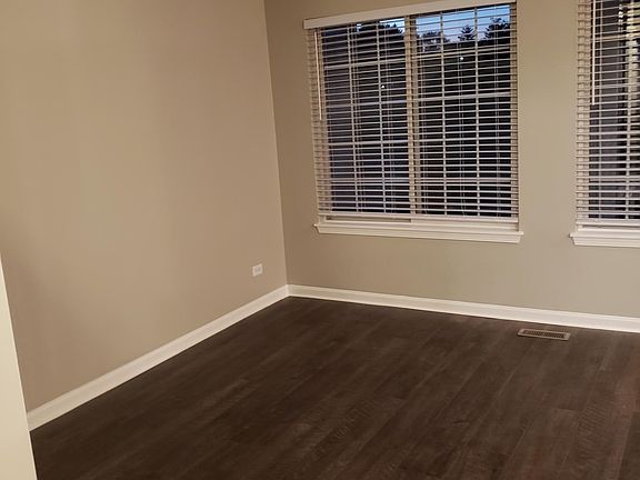 Great room with large windows. New vinyl plank flooring and freshly painted grey walls with white trim.