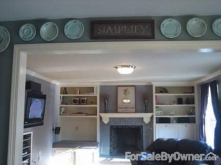 Family room : View through archway from the kitchen. Built in cabinetry with fireplace.