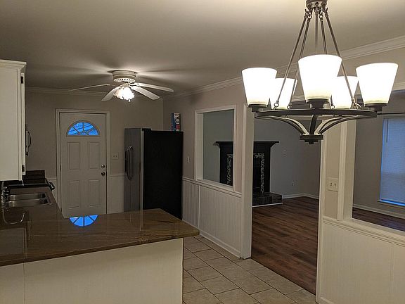 Kitchen with stainless steel appliances and custom granite counters. Open to the living room.