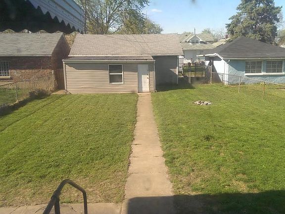 Back yard with view of garage and storage