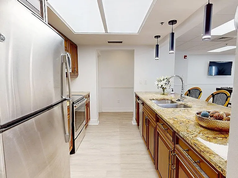 Sophisticated modern kitchen with granite countertops, stainless steel appliances, and elegant pendant lighting.