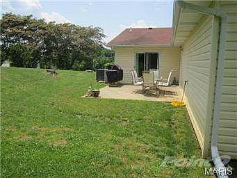 Back patio with sliding door off of the large kitchen