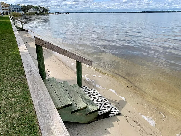 Shared community steps leading directly down to Perdido Bay's sandy shoreline for easy waterfront access.