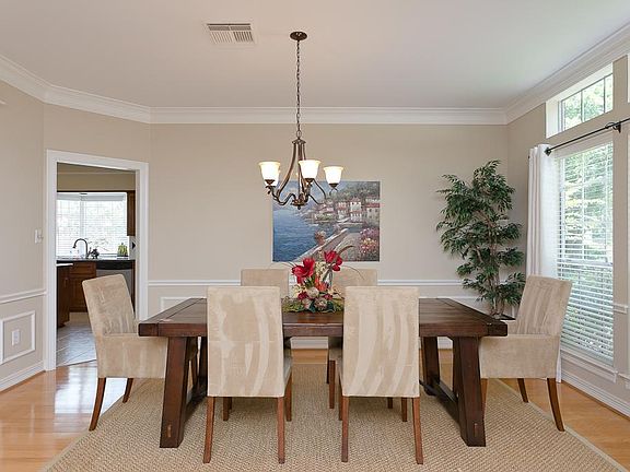 Formal dining room with newly installed hardwood floor and modern metal chandelier