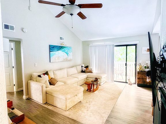 Living room with ceiling fan and vaulted ceiling