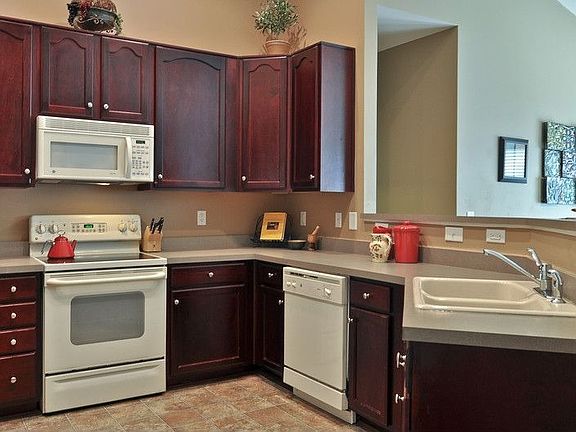 Kitchen has dark wood cabinets, loads of counterspace and a pantry.