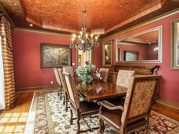 The Dining Room, to the left of the Entry Foyer, features a lovely coffered ceiling with custom handpainted detail.