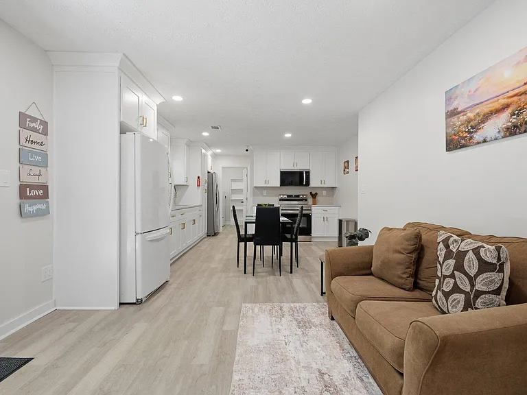Open-concept kitchen and dining area with ample cabinetry, full appliance suite, and adjacent lounge seating for easy living.