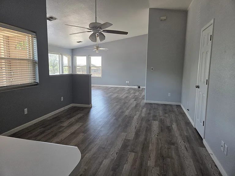 View from the kitchen through the dining room with a ceiling fan as well as another closet.