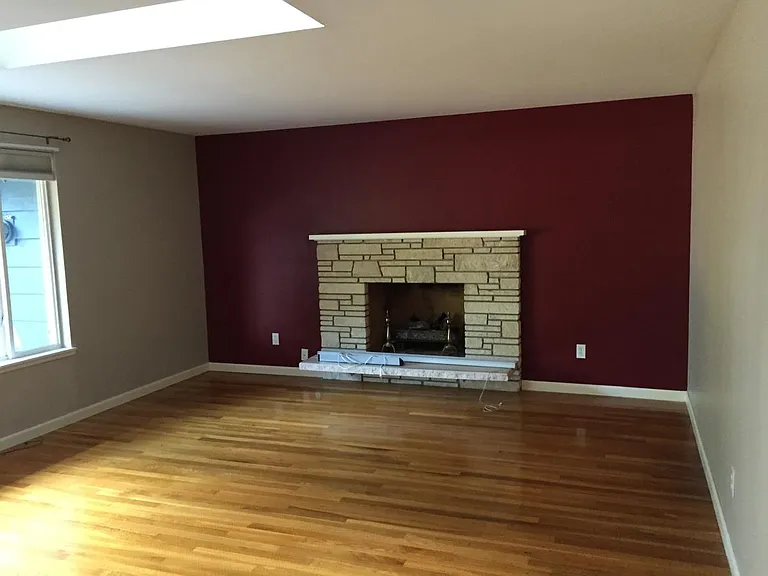 living room with gas fireplace + skylight