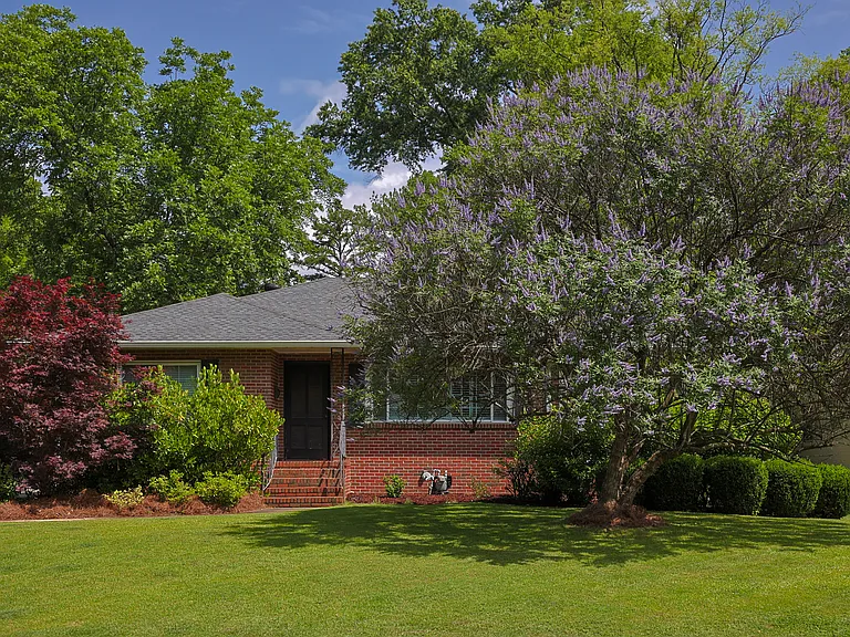 This beautiful brick home has mature landscaping including Japanese maples, a flowering dogwood, and a stunning chaste tree that blooms purple in the front yard.