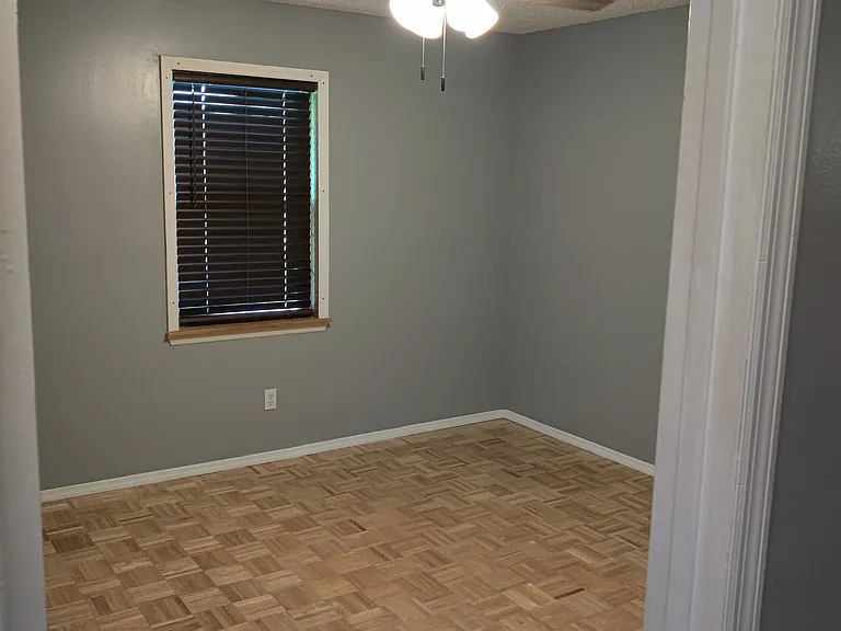1st bedroom with solid wood floor, closet, cieling fan and window with upgraded blinds (lift up or pull down by hand and look like wood/are wider/thicker)