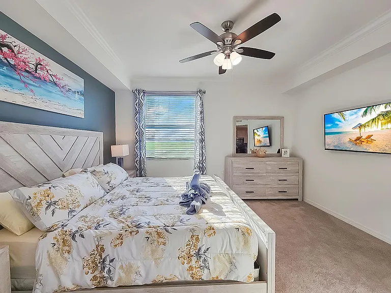 Master bed with smart screen tv that is cable ready and high-speed internet and a dresser with mirror