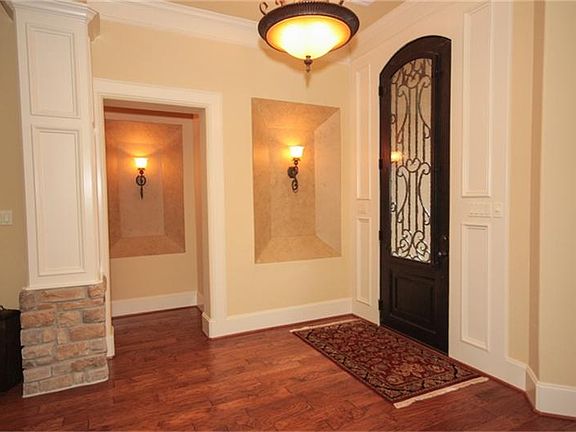  Wrought iron front door with handscraped  hardwoods.