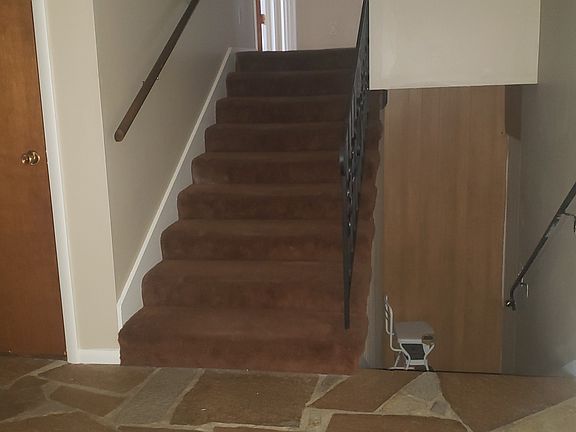 Stairs off entry way to the three bedrooms. Stairs going down to another bedroom, living room and bath currently occupied.