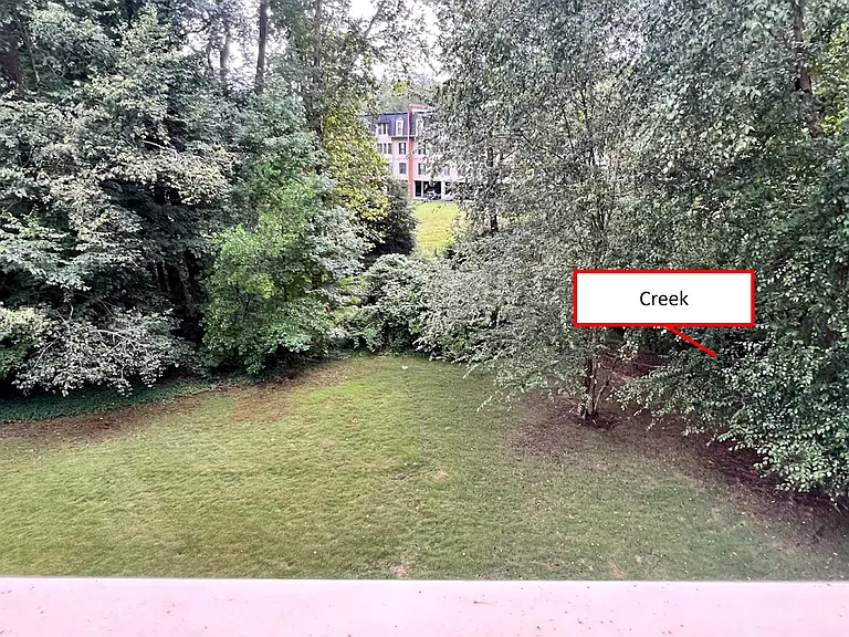 Balcony view. Creek runs at grass border.