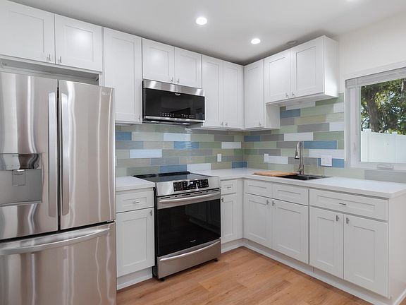 Beautiful new kitchen w/quartz countertops, glass tile backsplash, includes refrigerator/freezer, oven range, garbage disposal and & a microwave. Nice big window to see the yard.