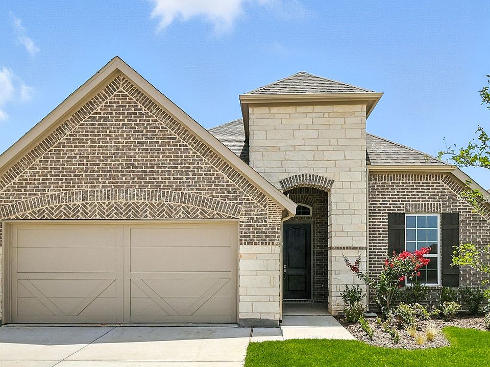 Luxurious brick facade with elegant arched entry and manicured landscape in Hulen Trails, Texas.